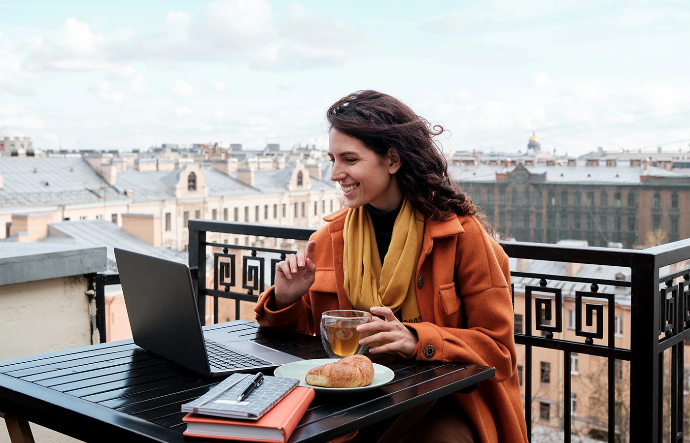 Mujer trabajando con su notebook en un café al aire libre